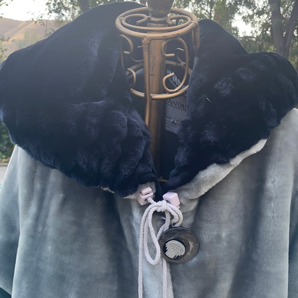 Dramatic plush oversize silvergrey winter coat. Contrasting midnight blue cuffs.